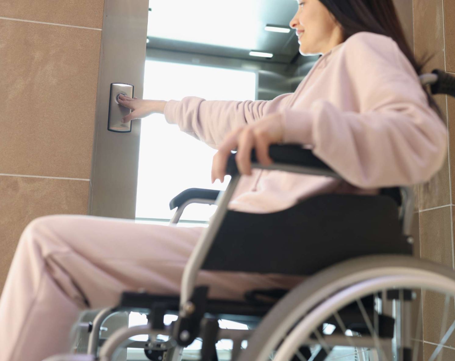 Người dùng xe lăn sử dụng thang máy trong nhà